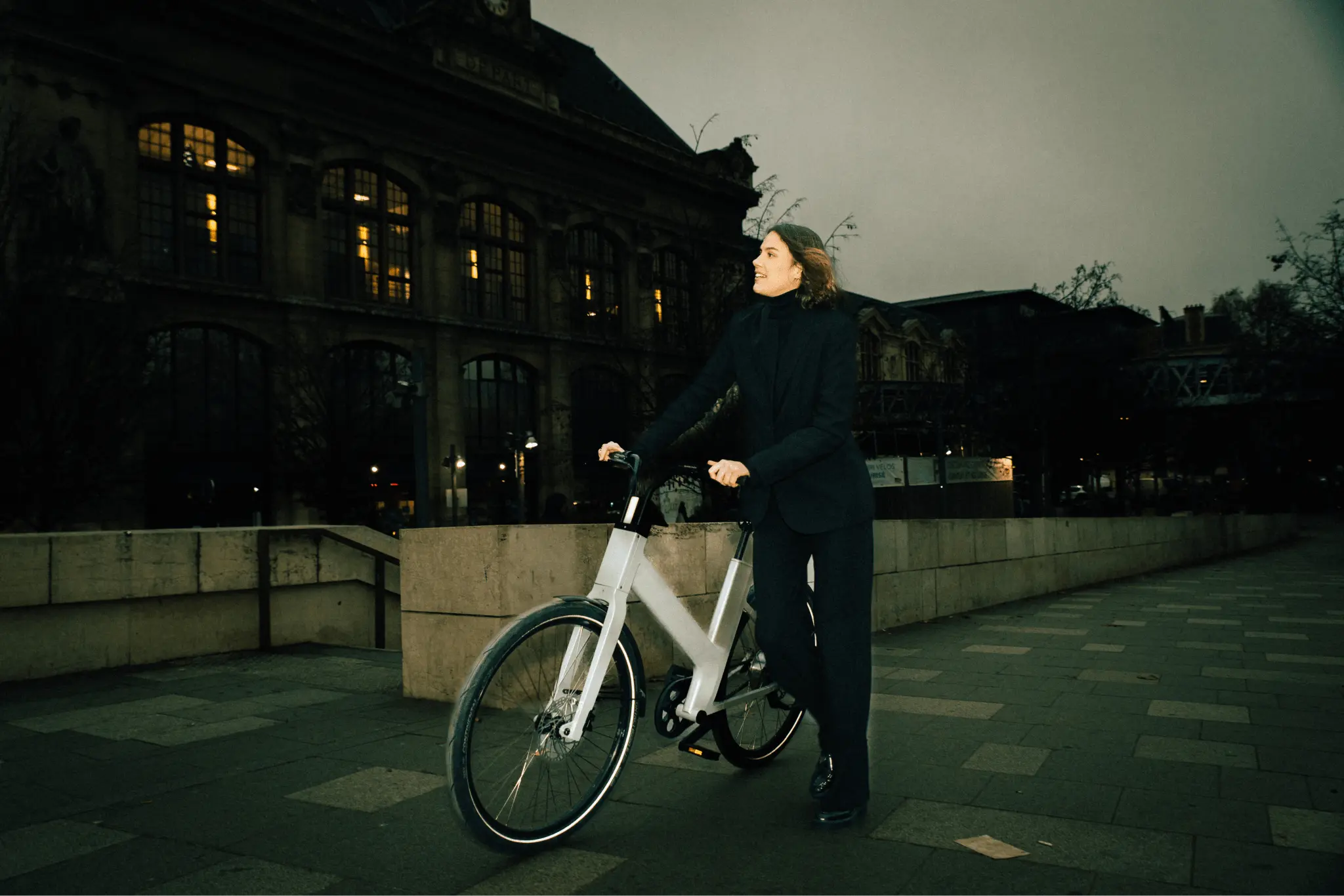 femme tient vélo hybride anod hybrid marche côté ville 