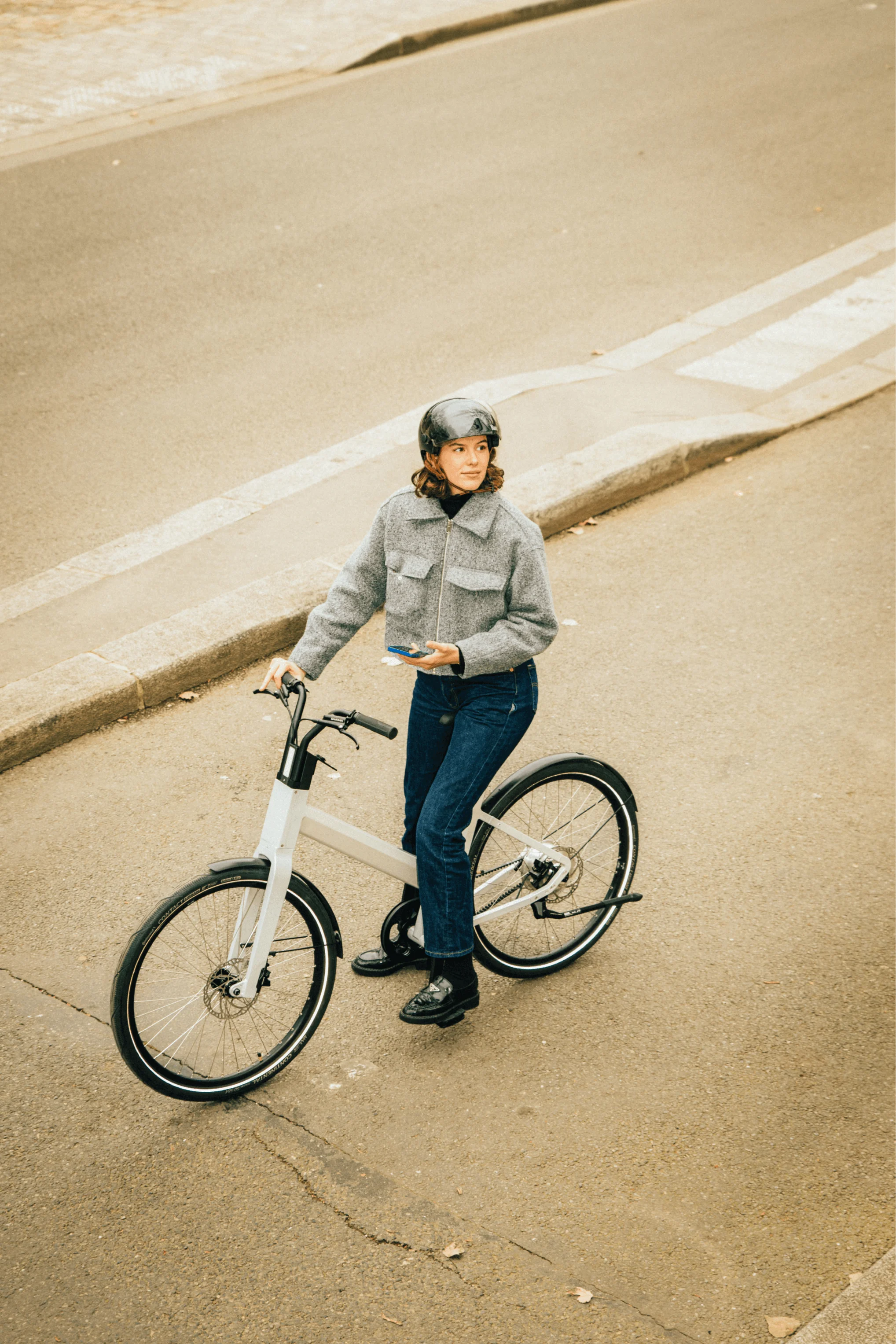femme vélo hybride anod hybrid tient téléphone