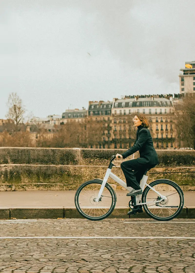 Femme sur un vélo électrique hybride anod sur un pont parisien version mobile
