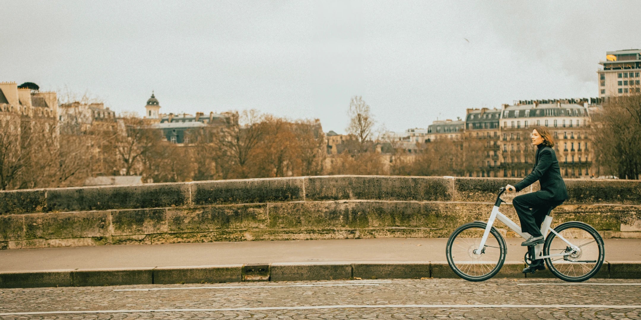 Femme sur un vélo électrique hybride anod sur un pont parisien