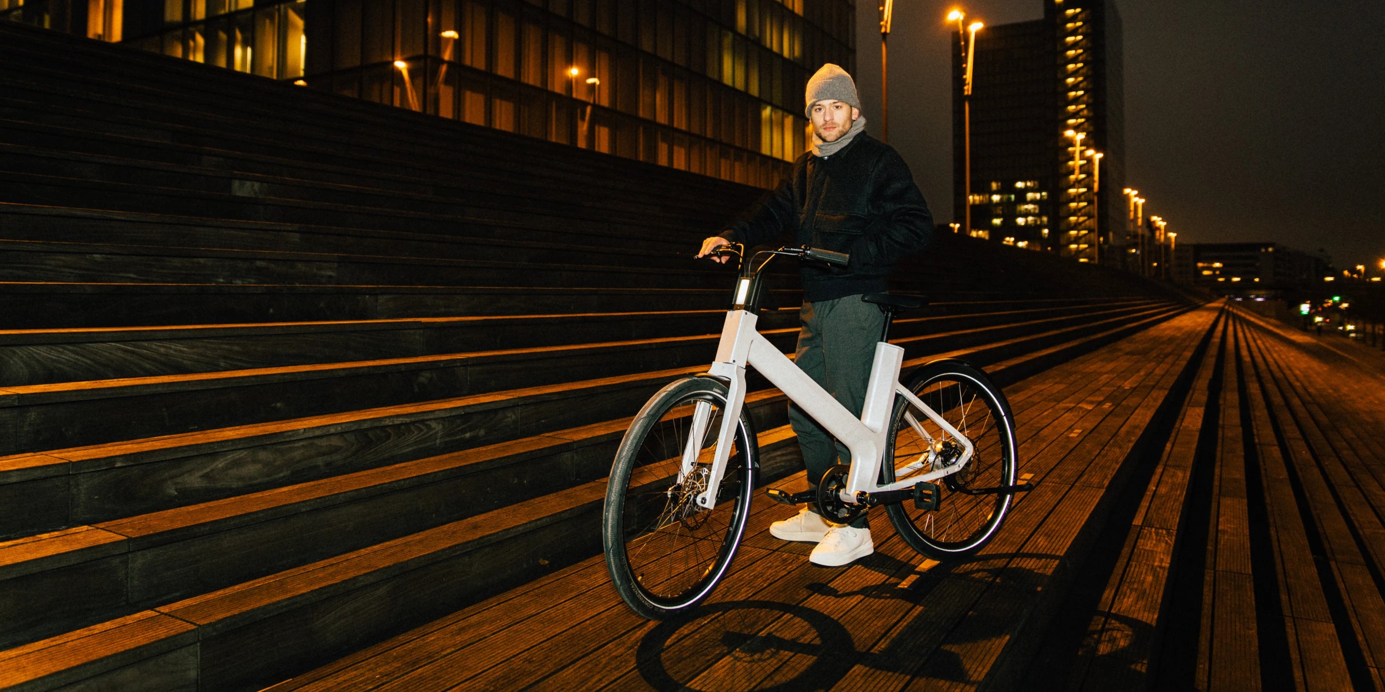 Homme qui pose avec le vélo électrique hybride anod dans la nuit